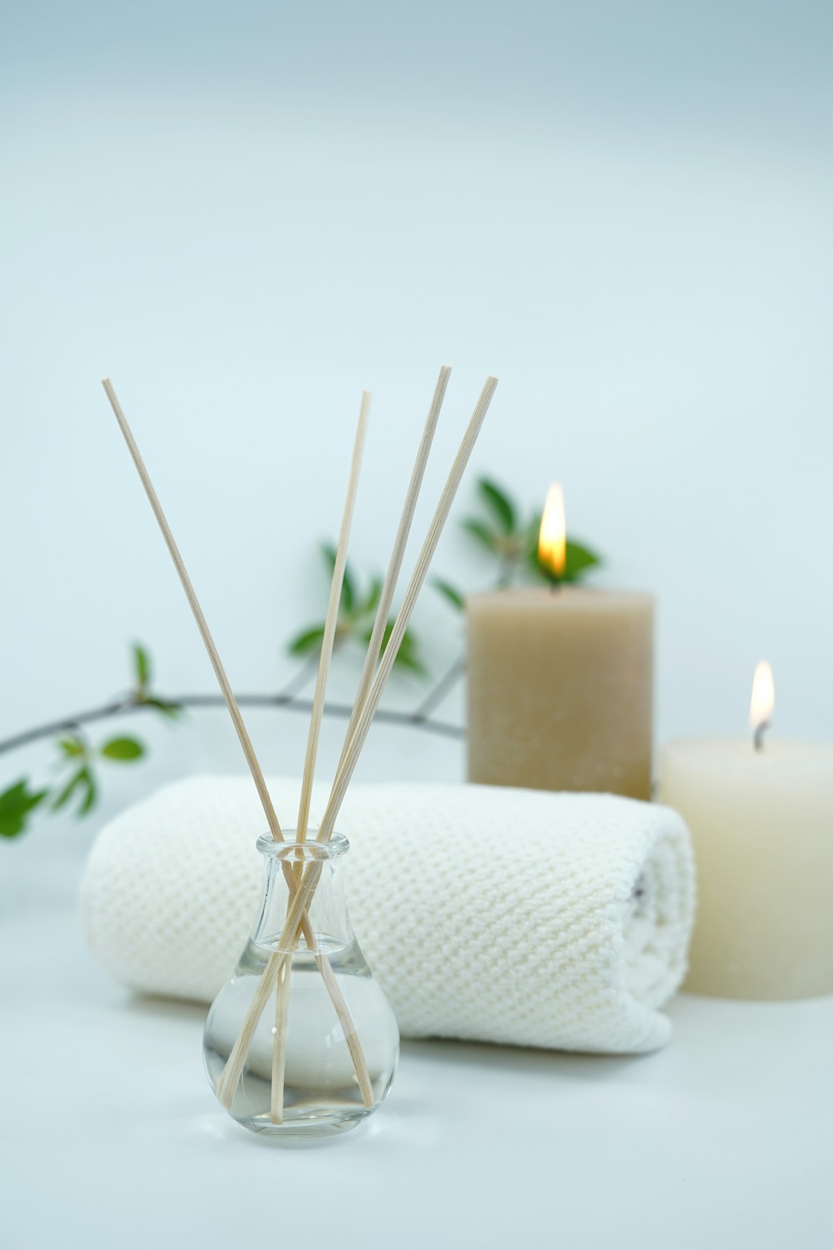 Reed diffuser, candles and folded towels in a quiet treatment room